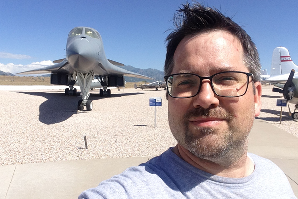 James Reynolds takes a selfie in front of several aircraft.