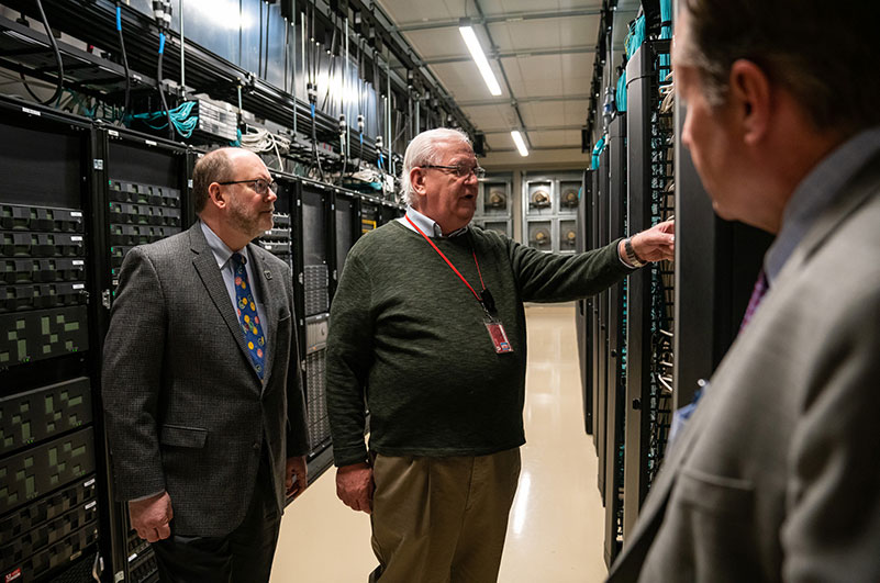Glen Cameron speaks to Senior Vice President for Academic Affairs Dan Reed, left, in February 2019 during a tour of the Downtown Data Center.