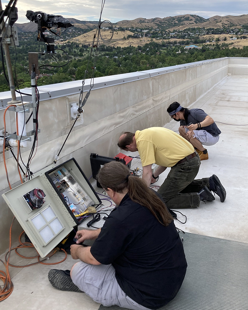 Professor Chris Anderson of the U.S. Naval Academy and Ph.D. students Yaguang Zhang and Bharath Keshavamurthy (not pictured) from Purdue University collect millimeter-wave channel state measurements on the roof of the William Browning Building for a moving vehicle scenario.