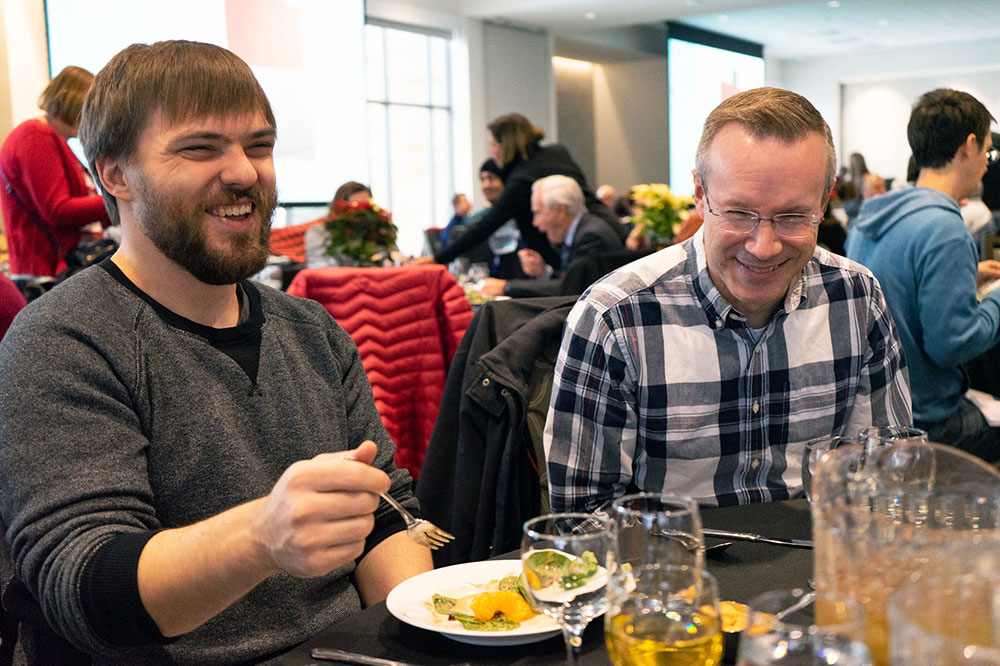 Mitch West, from left, and Doug Kenner laugh while eating lunch during the 2019 UIT holiday luncheon and prize drawing.