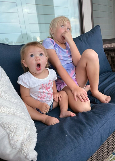 Raeleigh, left, and Blakely watch in suprise as some hummingbirds fight.