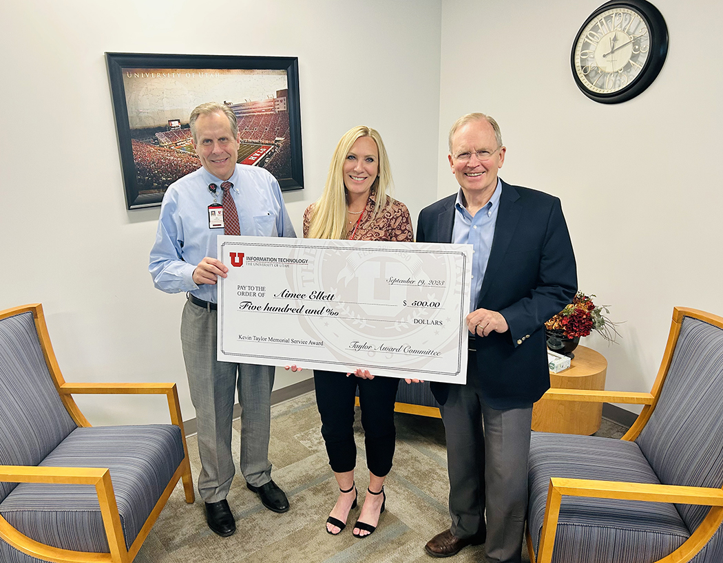 L-R: Chief Technology Officer Jim Livingston, Special Assistant to the CIO Aimee Ellett, and Chief Information Officer Steve Hess pose at 102 Tower with an oversized "check" denoting a $500 honorarium for Ellett, winner of the 2023-24 Kevin Taylor Memorial Service Award.