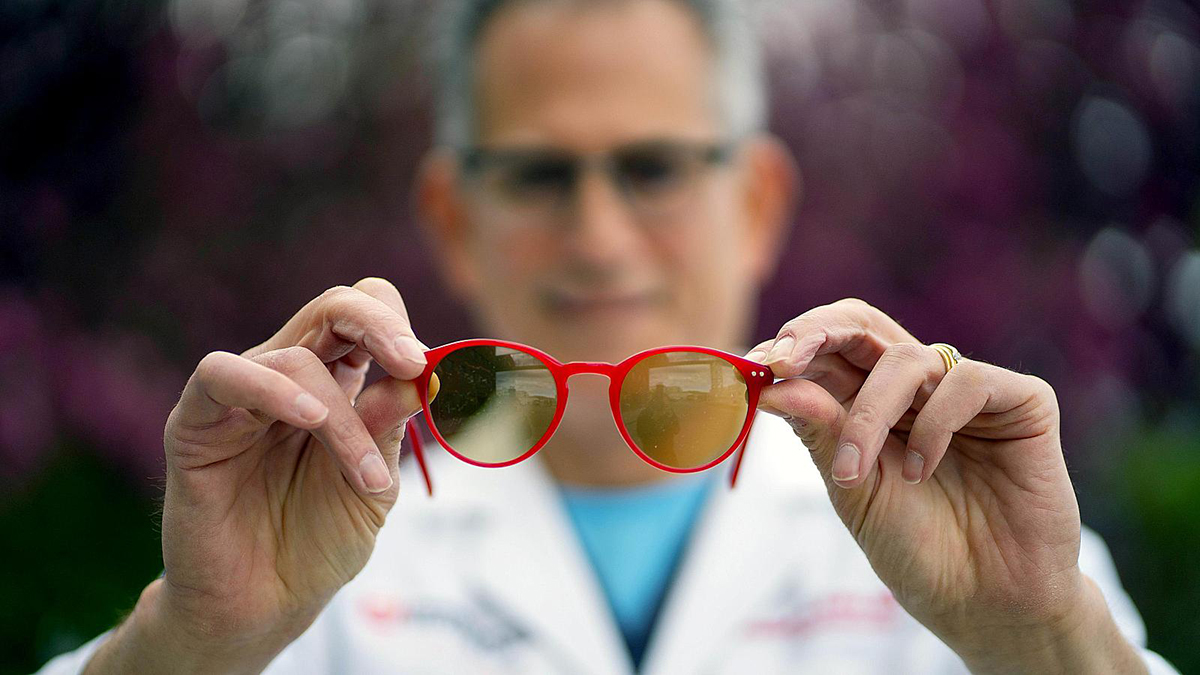 John A. Moran Eye Center neuro-ophthalmologist and scientist Bradley J. Katz, MD, holds a pair of Avulux eyeglasses designed to help wearers manage light sensitivity. Image courtesy of University of Utah Health.