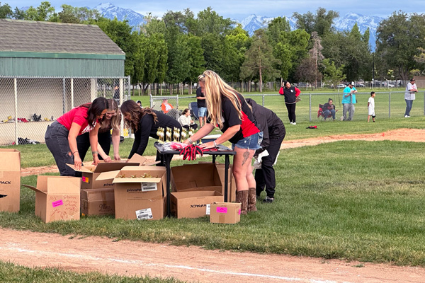 Winters (right) helps other volunteers organize medals and trophies for the league's players and coaches on June 3, 2024, during the closing day ceremony at Riverside Park. (Photo by Larrisa Beth Turner)