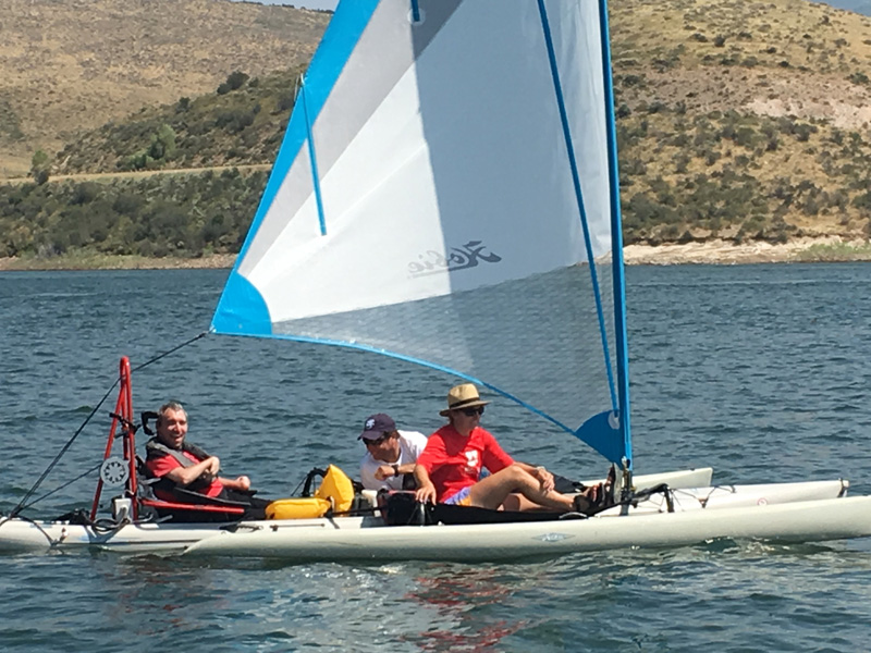 Allen's son, Britt (left), captains a Hobie Cat sailboat, an adaptive sailboat designed by the U's Tetradapt initiative that is controlled with a joystick. (Photo courtesy of Scott Allen)