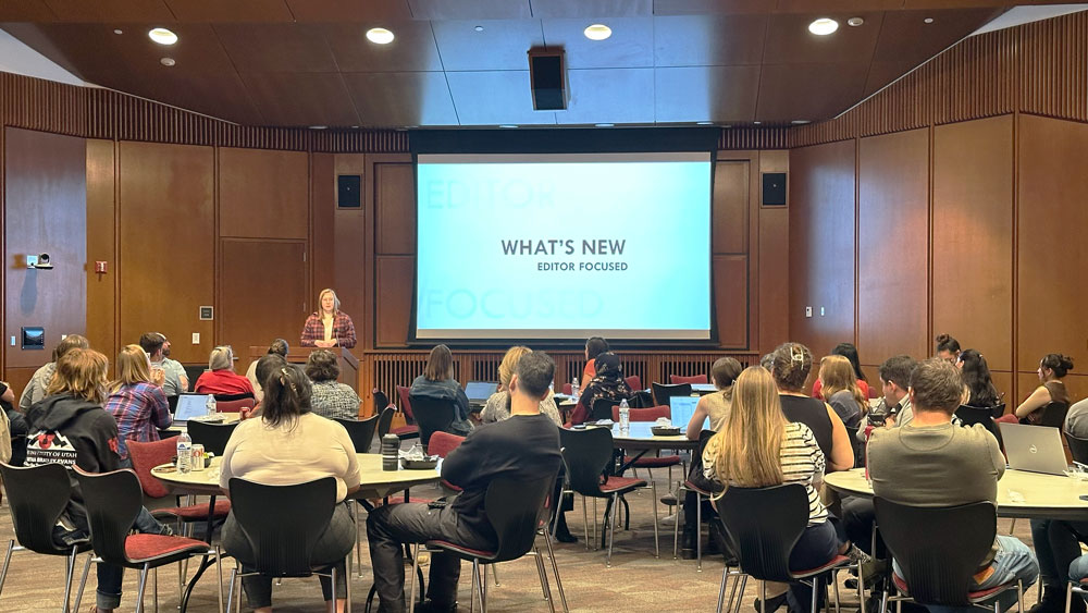 Abbey Allen, at lectern, gives a presentation on what's new in Modern Campus CMS on October 15, 2024, in Gould Auditorium in Marriott Library.