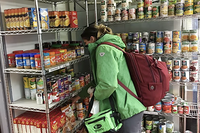 A patron selects a can of perishable food at the Feed U Food Pantry. (Photo courtesy of Office of Advancement)