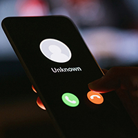 An unknown call is received by a mobile phone user.