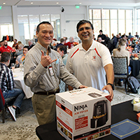 Peter Mo, manager of Data Management Platform Support Services, left, and Amir Masood, systems administrator for UIT's UMail & Collaboration team, at the UIT Holiday Luncheon on December 1