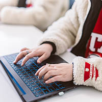 Image of a University of Utah Asia Campus student's hands typing on a laptop computer. Image courtesy of the University of Utah.