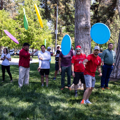 An SPS employee tosses five frisbees at once.