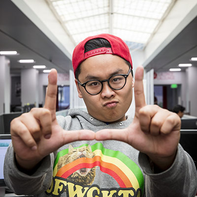 An Entertainment Arts and Engineering student “flashes the U” in the EAE master game studio. Image courtesy of the University of Utah.