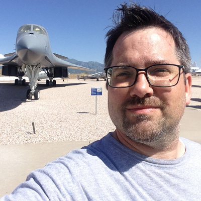 James Reynolds takes a selfie in front of several aircraft.