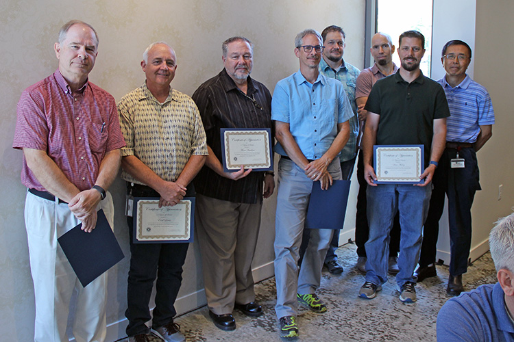 L-R: Alan Wisniewski, Earl Lewis, Marv Hawkins, Brett Milash, Jake Johansen, Matt Leatham, Steve Maloy, and Joey Yang  were honored for 15 years of service to UIT during the September 17 All-Hands Meeting at the Alumni House.