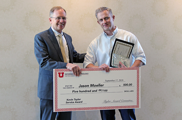 L-R: CIO Steve Hess congratulates Kevin Taylor Memorial Service Award winner Jason Moeller, who was presented with a $500 check at the September 17 All-Hands Meeting at the Alumni House.