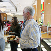 Bryan Harman waits in line for food the Student Affairs winter luncheon.