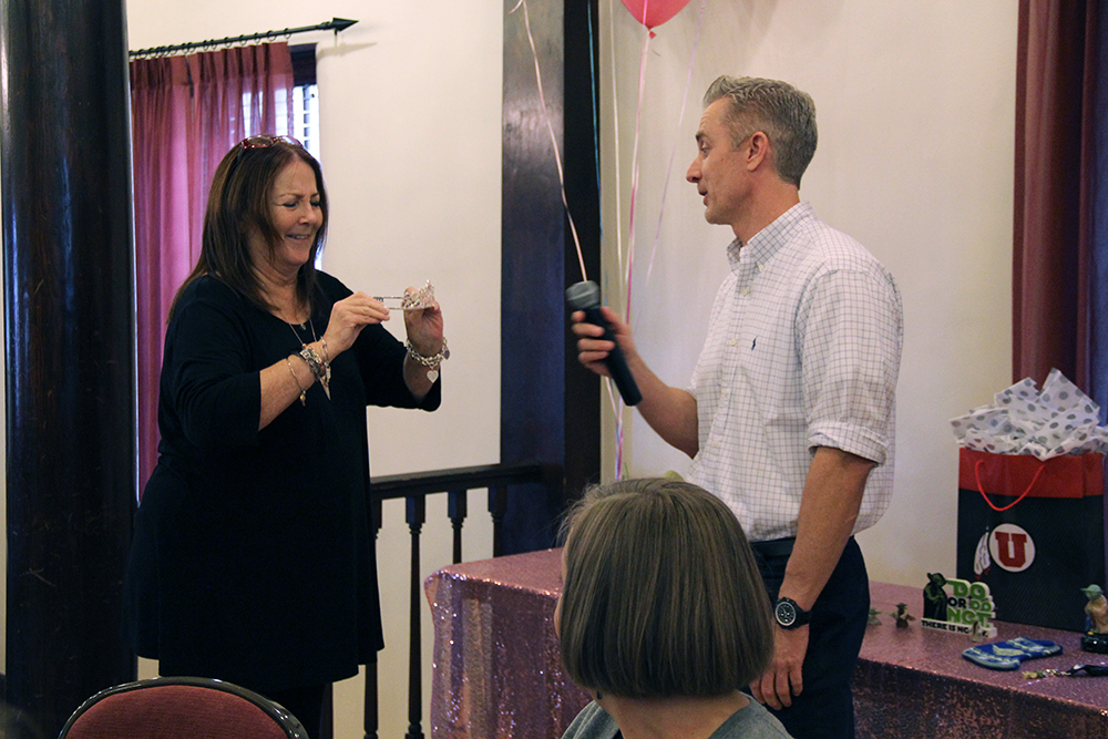 University Support Services Data Analyst Camille Wintch, left, laughs while holding the tiara her boss, Associate Director Jason Moeller, gave her to wear for her retirement party on November 21, 2019.