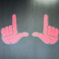 A wall is painted with red hands forming the U sign. 