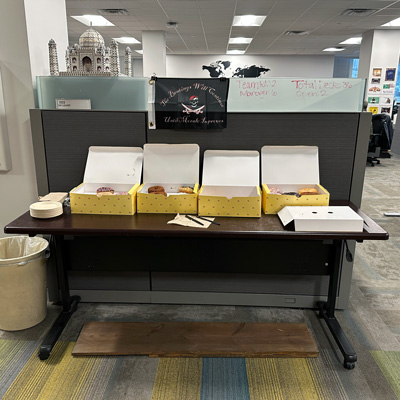 Breakfast included doughnuts and decor from previous International Talk Like a Pirate Days — a small flag that reads “The beatings will continue until morale improves” and a plank that Ryan Hines carried in on his bicycle.