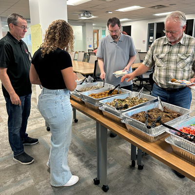 Employees assemble Mediterranean-style salad bowls during a start of school lunch.