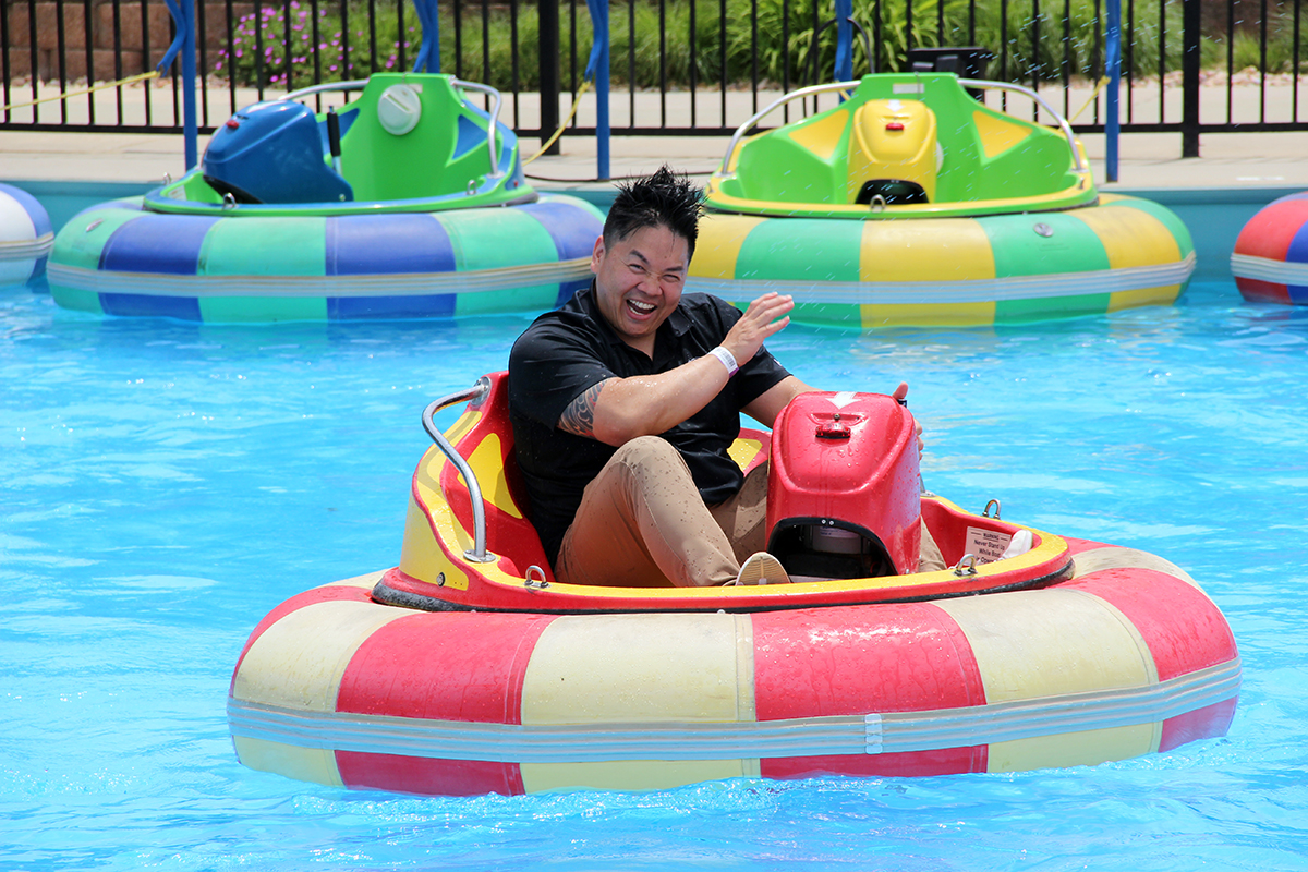 Luc Nguyen, systems administrator for UIT's Service Management for Platform Services team, reacts to getting sprayed on the bumper boat attraction.