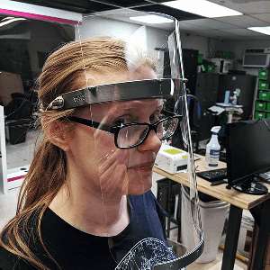 Beth Sallay models a face shield that her team 3D printed and laser cut at Make Salt Lake as part of its COVID-19 PPE project. (Courtesy of Beth Sallay)