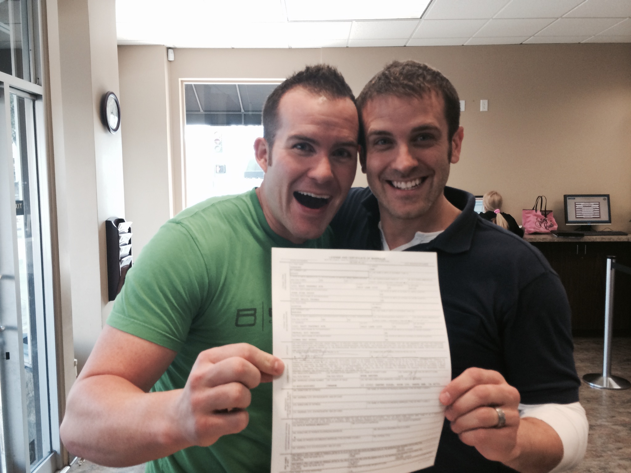 Spencer Stout and Dustin Reeser pose with their marriage certificate.